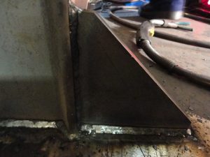 FCAW weld on gusset using a E71-T electrode in the horizontal position or 1f position.