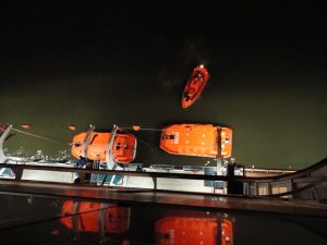 Carnival Spirit lifeboats being lifted onto ship.