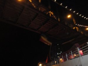 Carnival Spirit passing under the Golden Gate Bridge at night.